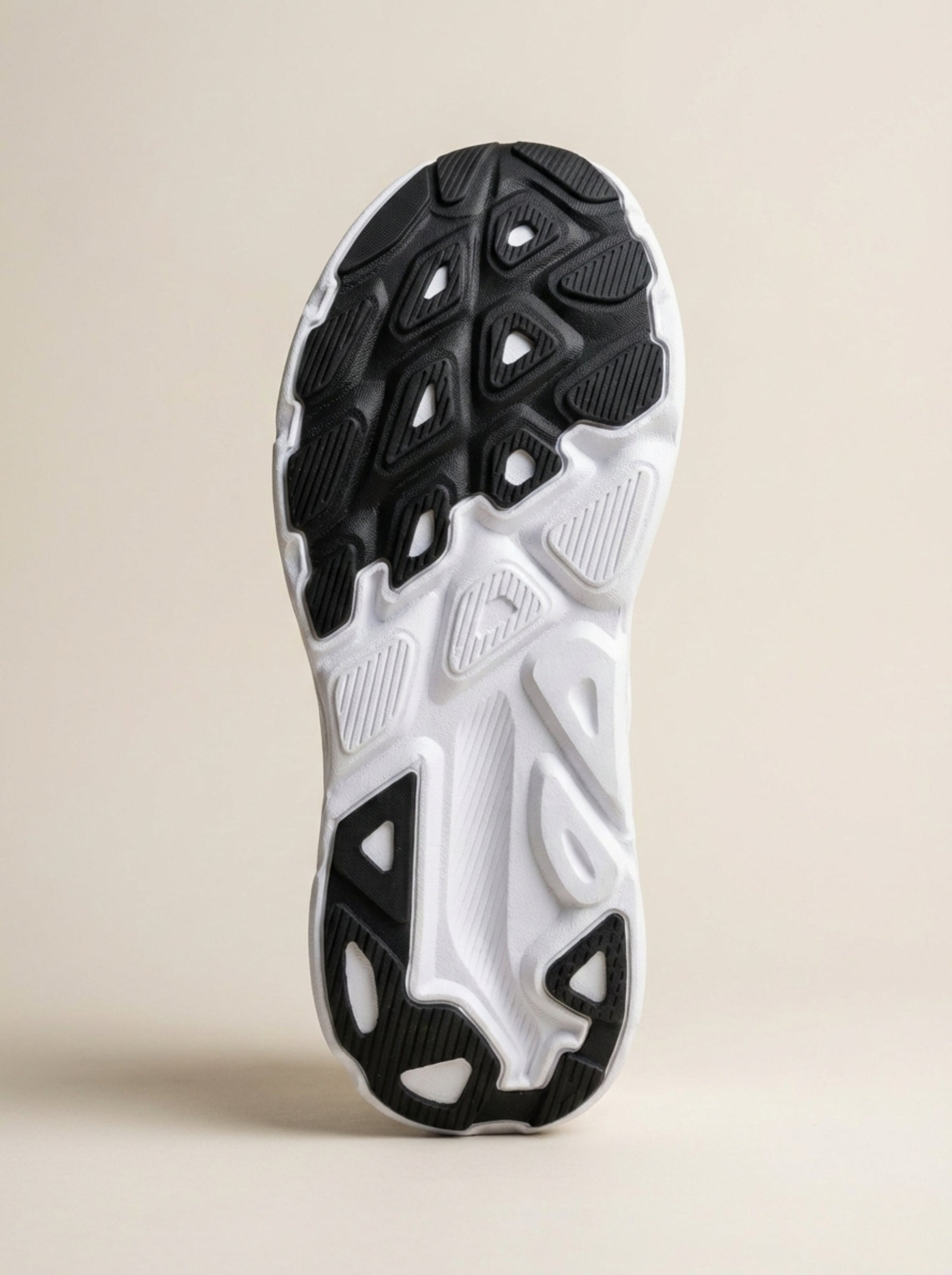 Close-up of a black and white athletic shoe sole on a beige background