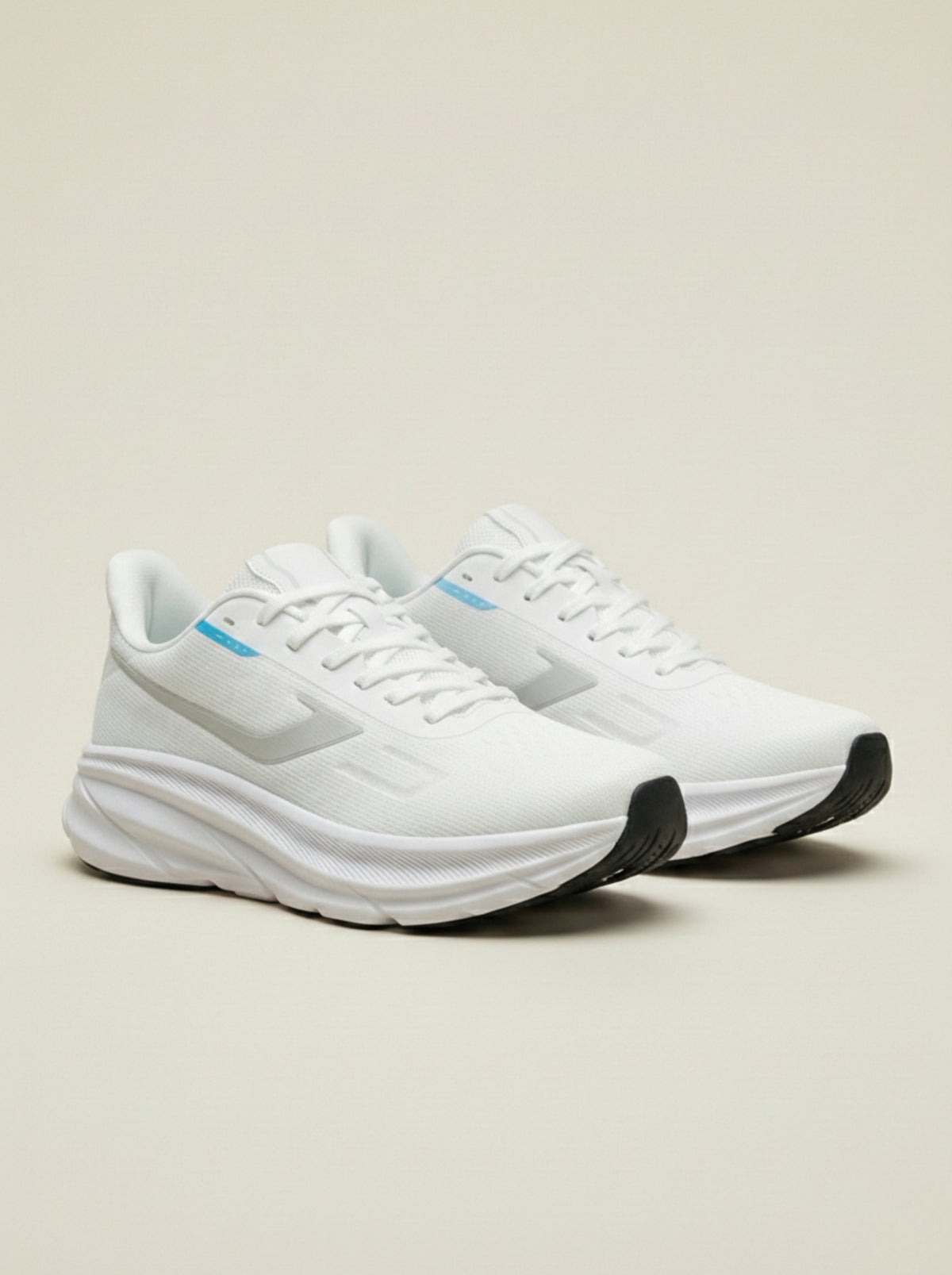 White running shoes with black soles on a light beige background