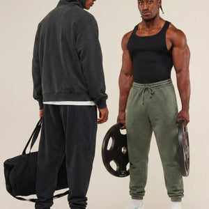 Two men in athletic wear standing next to each other with gym equipment.