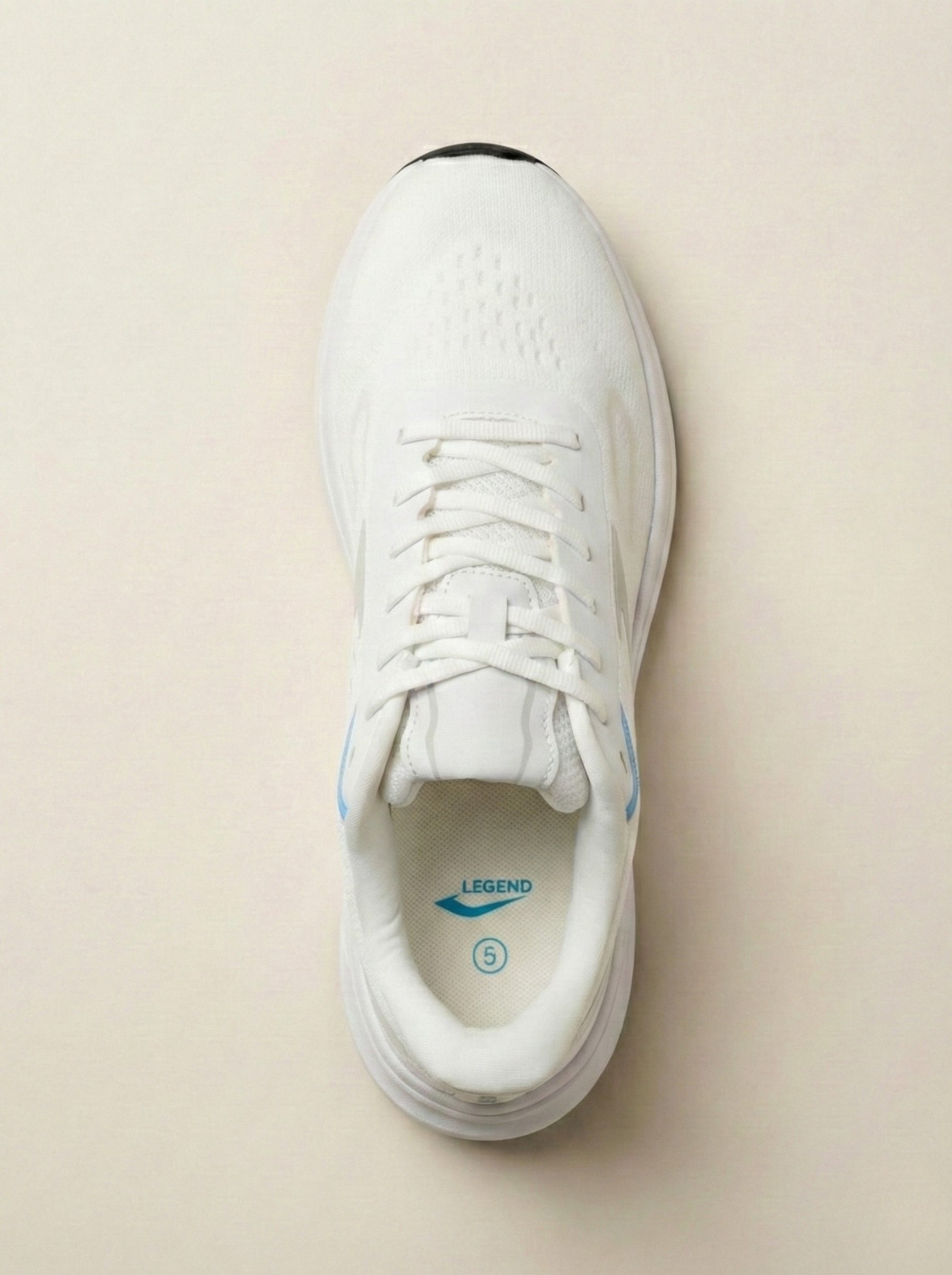 White sneaker with blue accents on a beige background